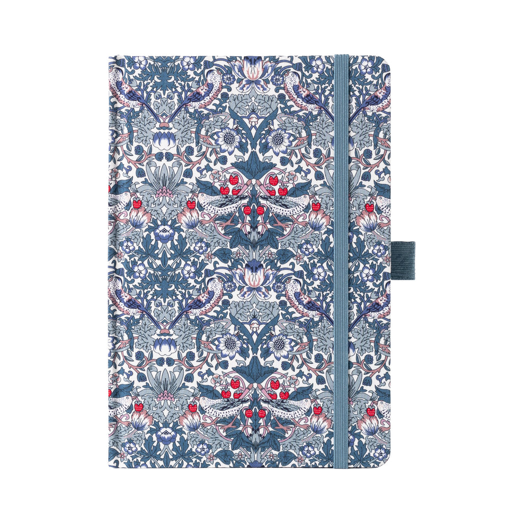 A5 blue ornamental floral fabric notebook standing upright on a white background with a matching blue elastic closure, featuring an intricate symmetrical botanical pattern with red and white accents.