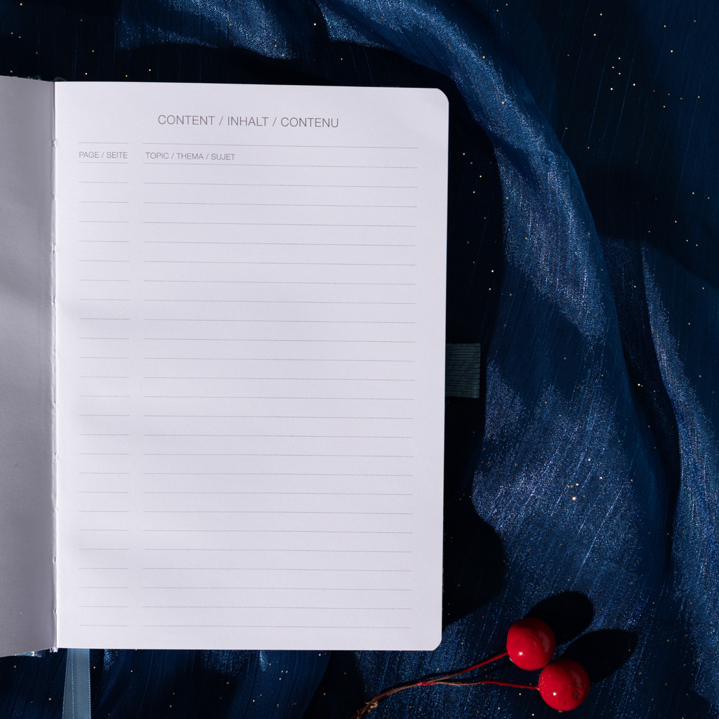 Close-up of the content index page of the blue floral notebook, showing "CONTENT / INHALT / CONTENU" headers and "PAGE / TOPIC" lined sections.