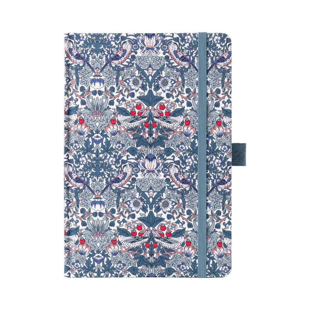 A5 blue ornamental floral fabric notebook standing upright on a white background with a matching blue elastic closure, featuring an intricate symmetrical botanical pattern with red and white accents.