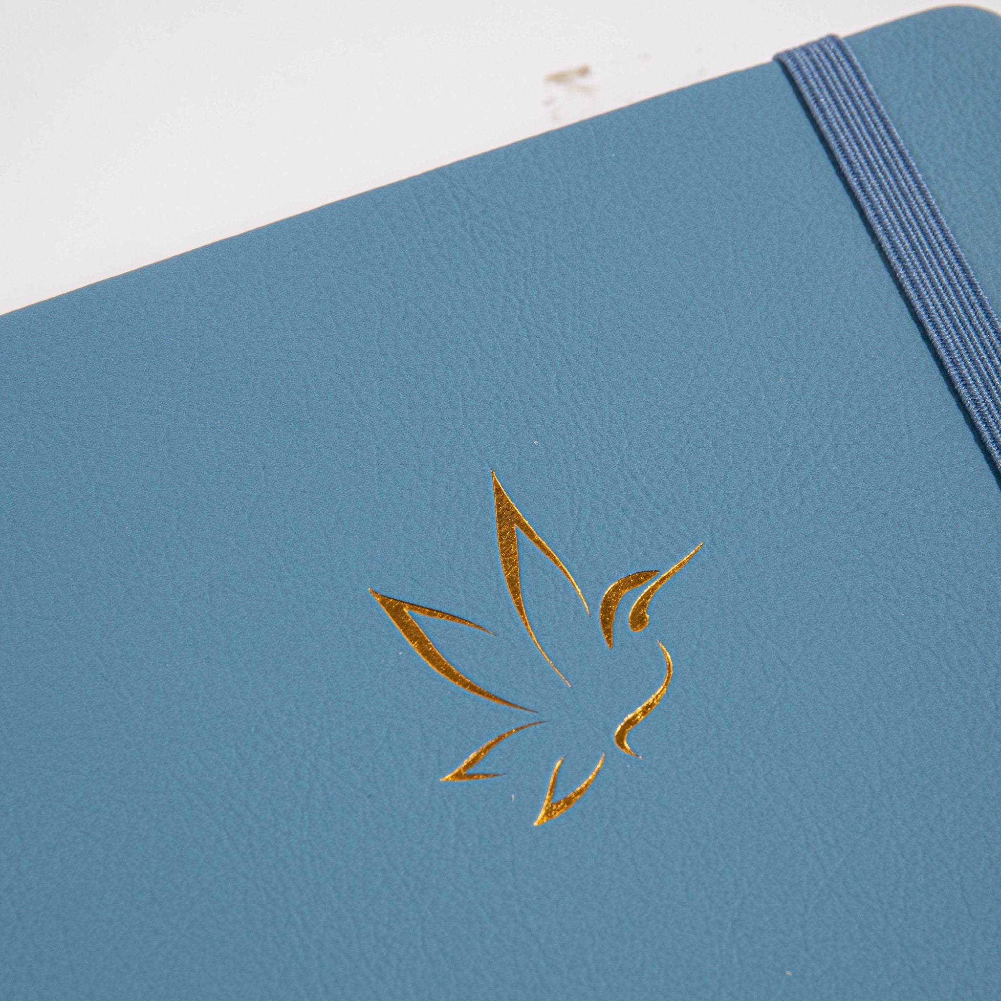 A5 Blue Vegan Leather Hummingbird Notebook Close-up, Gold Foil Hummingbird Emboss with Dried Flowers