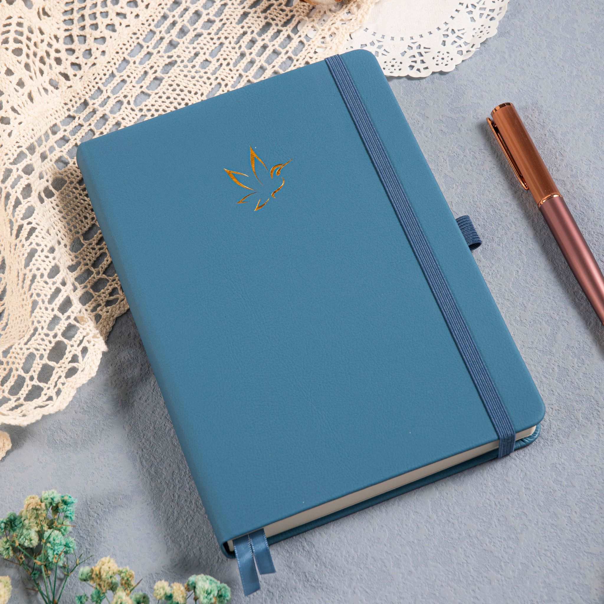 A5 Blue Vegan Leather Hummingbird Notebook on Desk with Dried Flowers and Pen