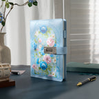 A5 light blue vegan leather journal with a metal combination lock, featuring a floral arch design with blue and pink roses, standing upright on a dark desk with a wooden calendar and a patterned pen.