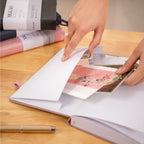 MGGAO A5 Couple Pink Vegan Leather Hummingbird Notebook with Expandable Inner Pocket, Hand Pulling on Wooden Desk
