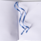 Open A5 lined notebook showing clean horizontal pages with a light blue satin ribbon bookmark elegantly draped, and Memo No. and Date headers at the top right corner.