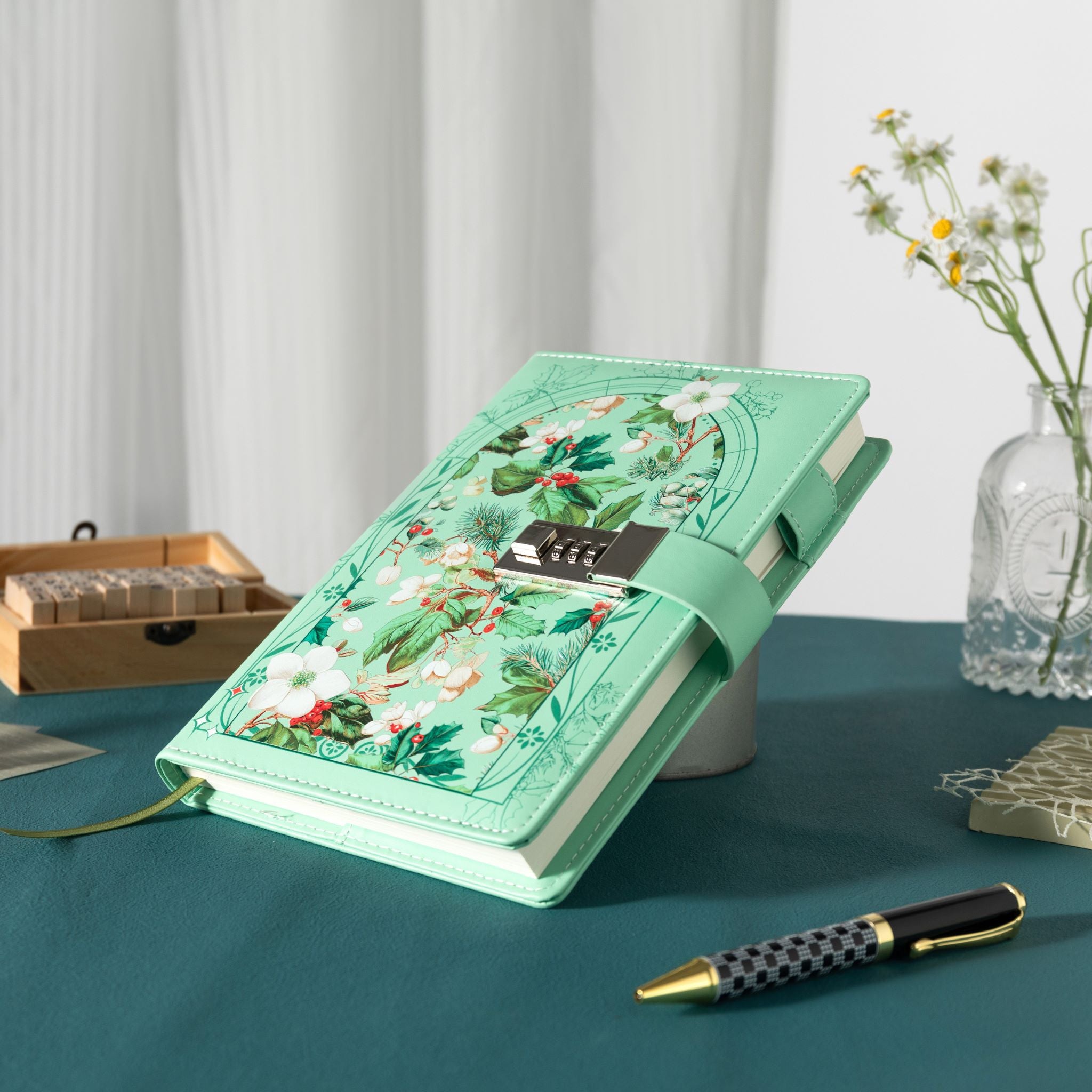 Angled view of the green floral lockable notebook resting on a dark green surface, showcasing the botanical arch design and metal lock.