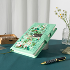 Angled view of the green floral lockable notebook resting on a dark green surface, showcasing the botanical arch design and metal lock.