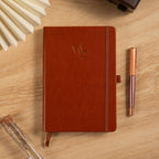 A5 Red Vegan Leather Hummingbird Notebook on Desk with Wooden Pen and Fan