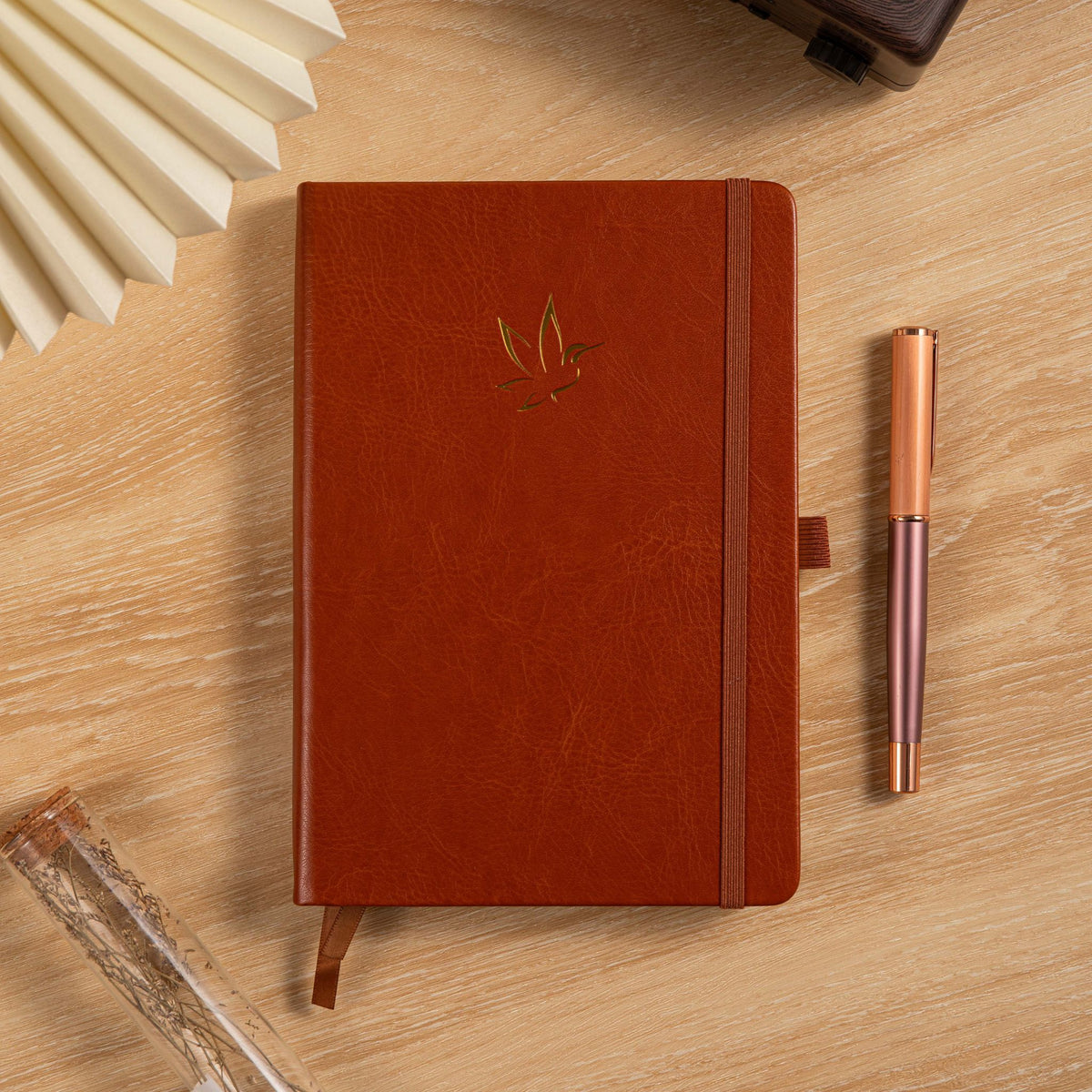 A5 Red Vegan Leather Hummingbird Notebook on Desk with Wooden Pen and Fan