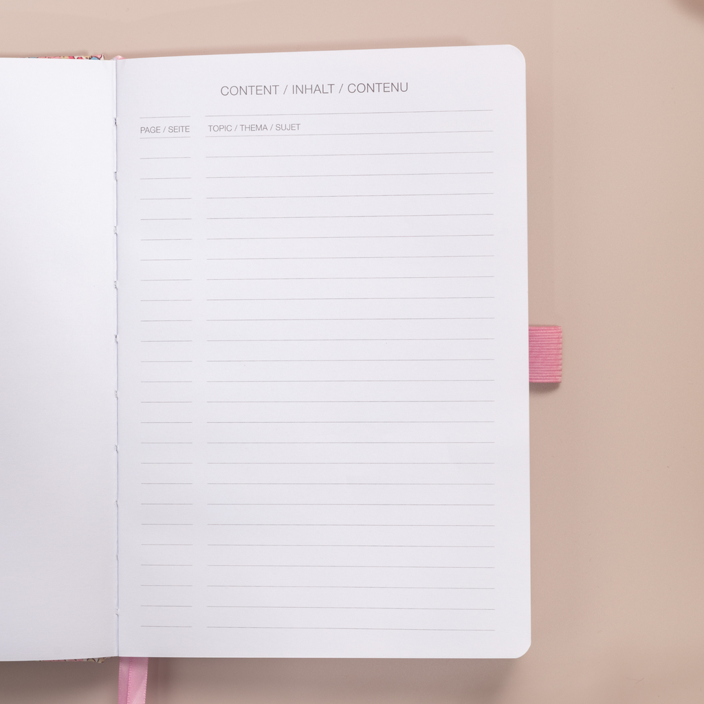 Close-up of the content index page of the pink ditsy floral notebook, showing "CONTENT / INHALT / CONTENU" headers and lined topic sections.