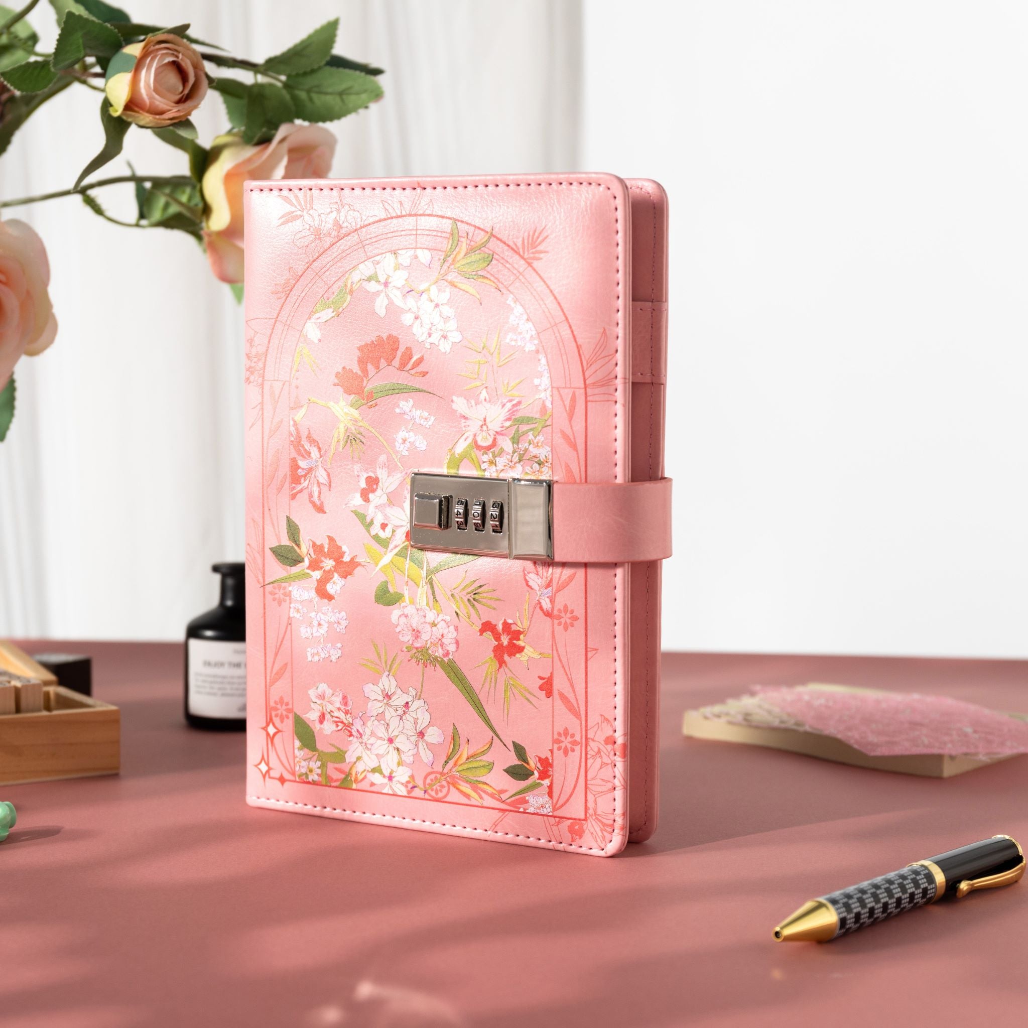 A5 pink floral lockable journal standing upright on a pink desktop, featuring a secure combination lock and rose decor. 