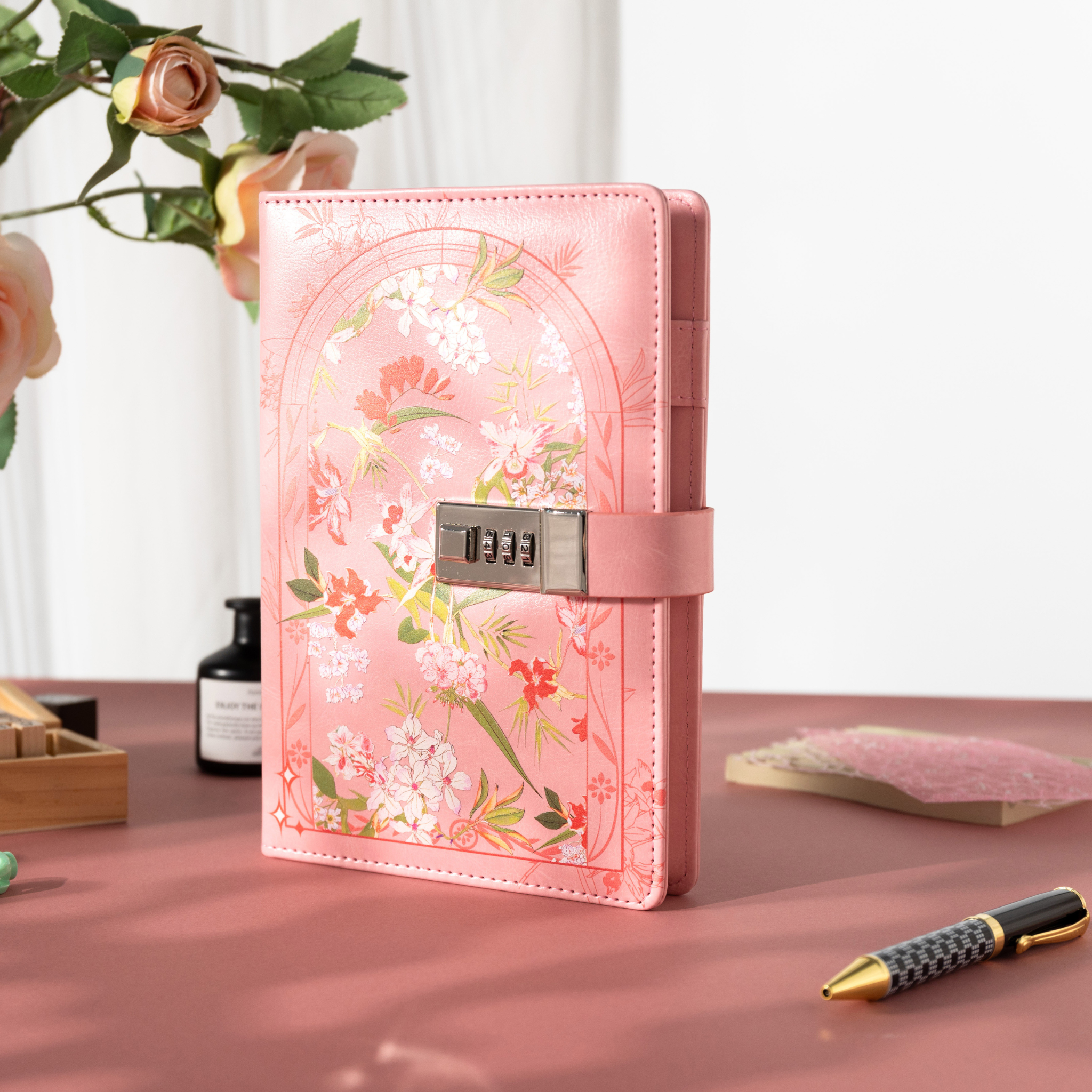 A5 pink floral lockable notebook standing upright on a pink desktop, featuring a secure combination lock and rose decor. 