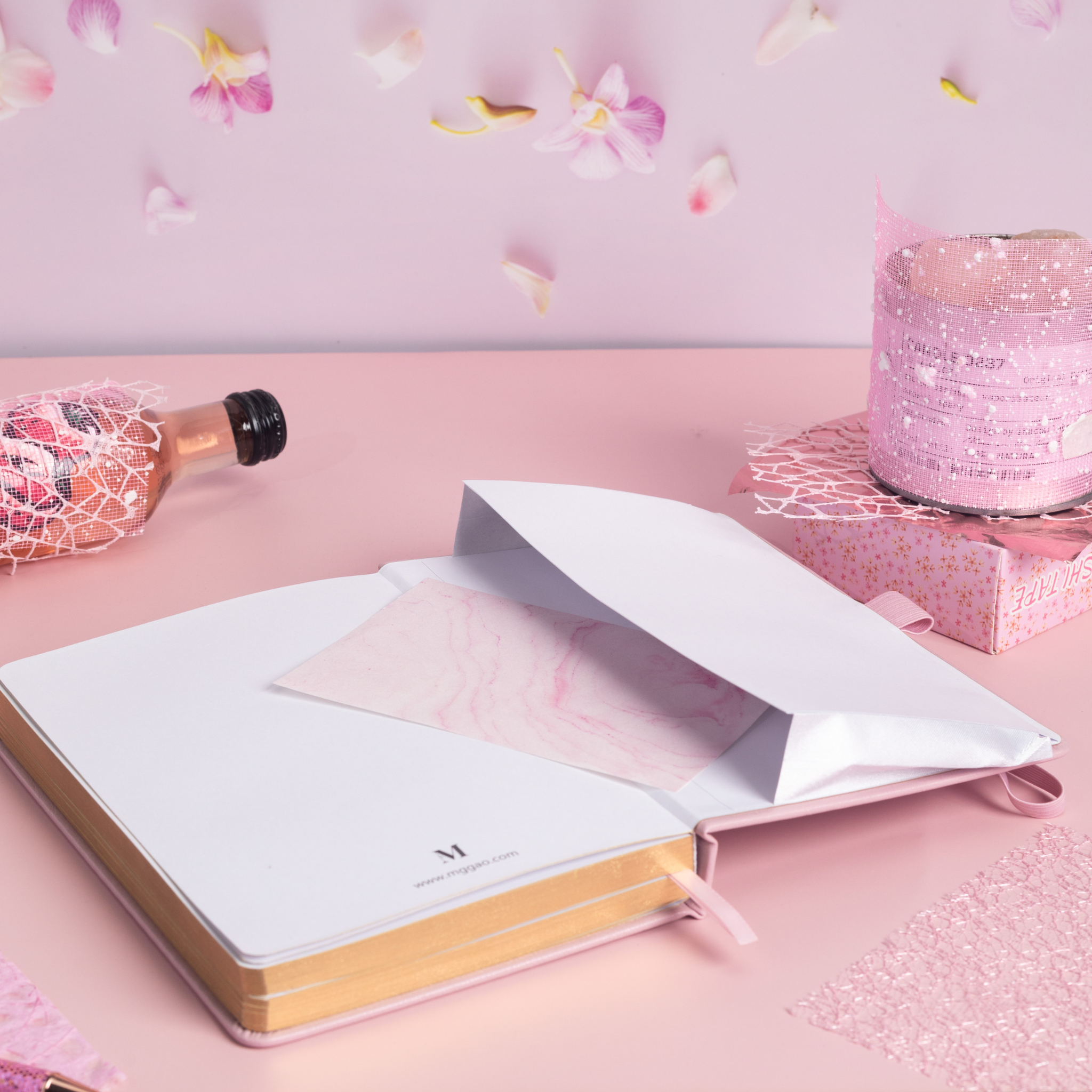 Inner back pocket of the pink vegan leather notebook holding a pink marble card, with gold gilded edges visible at the bottom.