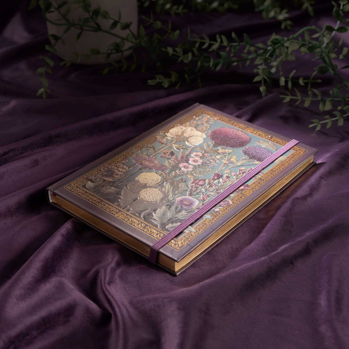 A5 Purple Taupe Floral Tapestry Hardcover Notebook Flat Lay on Purple Silk, Gold Gilded Edges with Plants Background
