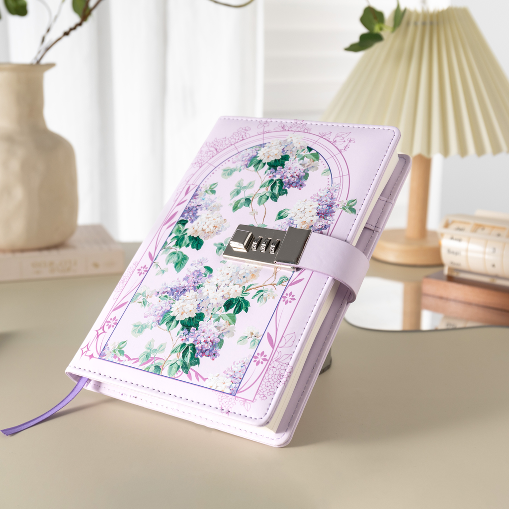 Angled view of the purple floral lockable notebook resting on a light beige surface, showcasing the botanical arch design and metal lock.