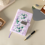 Top-down view of the purple floral vegan leather notebook laid flat on a beige surface, featuring a botanical arch design, a 3-digit metal combination lock, a purple ribbon bookmark, and styled with a patterned pen and wooden stamps.