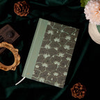 A5 Wind Flowers Hardcover Lined Notebook Side View on Dark Green Silk, Gold Foil Spine and Water Lily Cover Detail