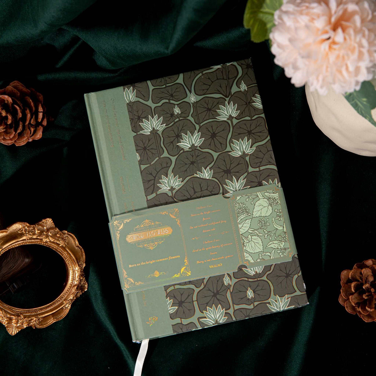 A5 Wind Flowers Hardcover Lined Notebook Flat Lay on Dark Green Silk, Green Gold Foil Cover Detail