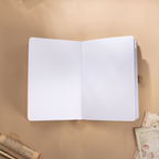 Open A5 journal laid flat on a wooden surface, displaying the clean 160gsm dot grid paper interior with a beige ribbon bookmark.