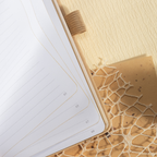Close-up of the open beige vegan leather notebook, highlighting the 100gsm lined paper interior with elegant gold borders, corner page numbers, and a matching beige elastic band.
