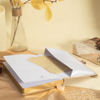 Close-up of the inner back pocket of the beige vegan leather notebook, holding a golden card and showing the gold gilded pages.