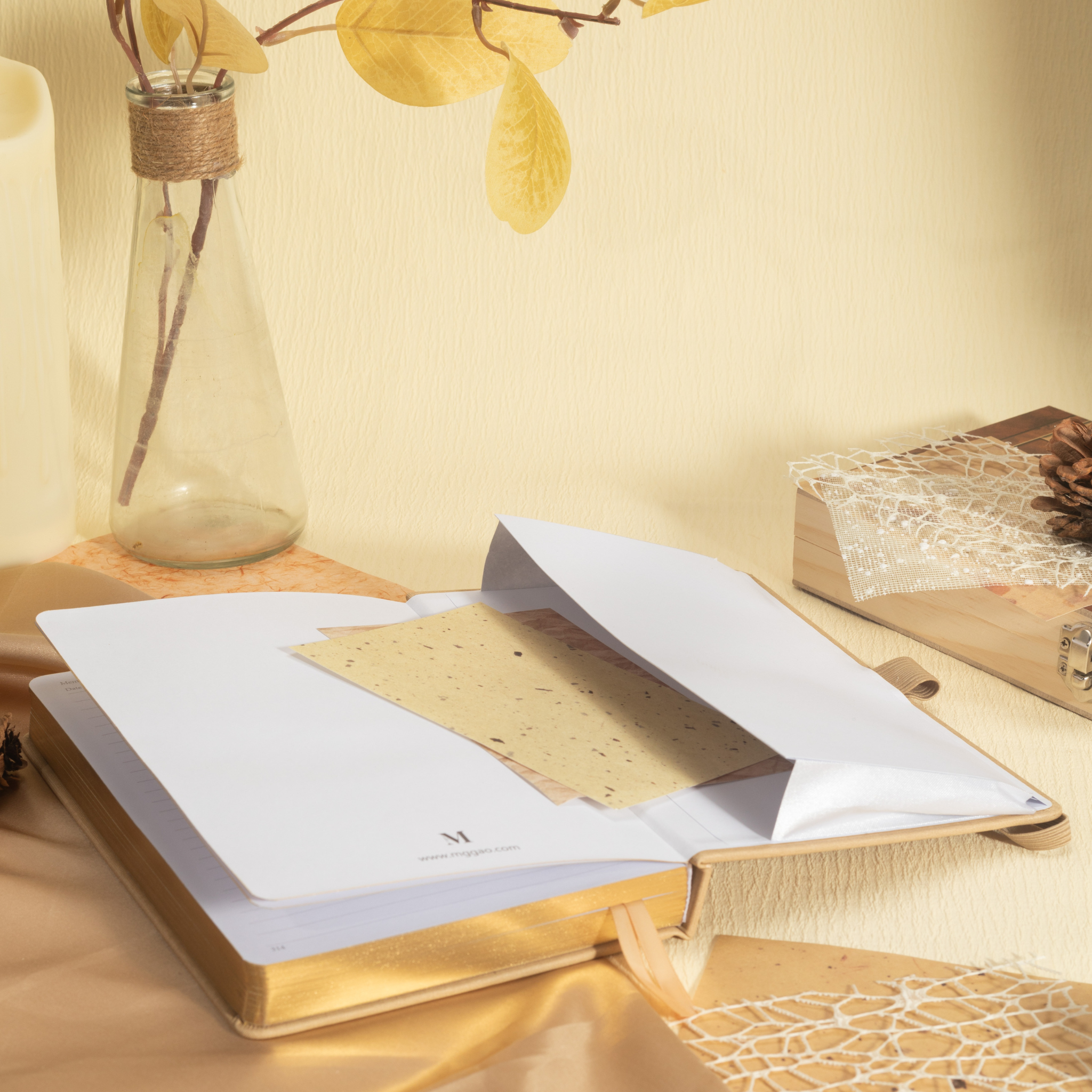 Close-up of the inner back pocket of the beige vegan leather notebook, holding a golden card and showing the gold gilded pages.