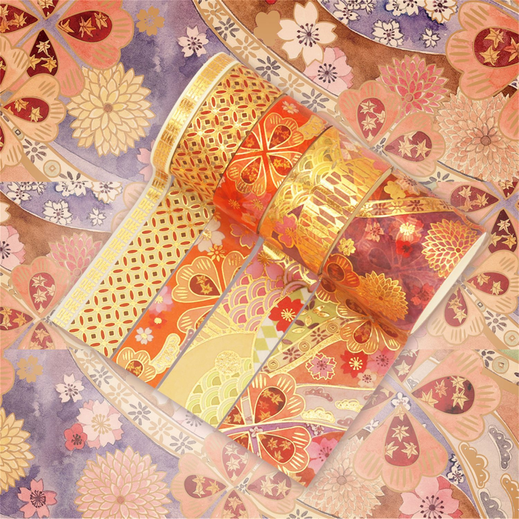 Orange, red, and purple blossom washi tapes partially unrolled on a warm floral background, showcasing intricate gold foil geometric lattice, fan-shaped floral patterns, and colorful floral motifs.