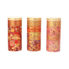 Three rolls of blossom gold foil washi tape in varying widths and pink, red, and gold floral patterns, standing upright on a white background.