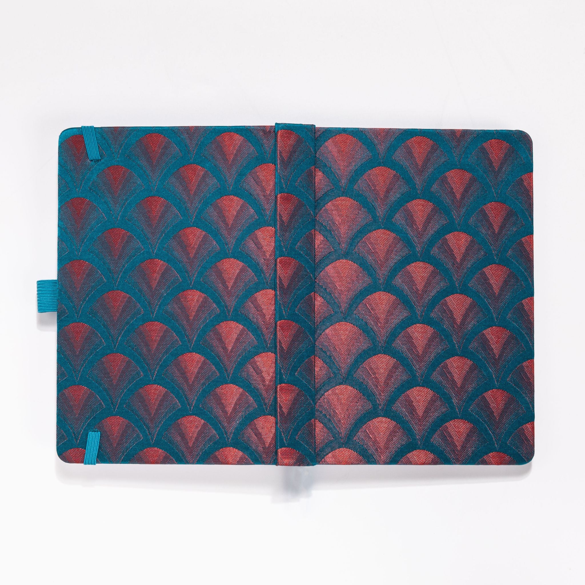 Flat lay of the teal-blue and red-copper embroidered scalloped fabric cover