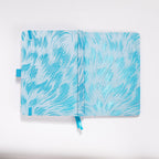 Flat lay of the white and light blue embroidered fabric cover opened completely