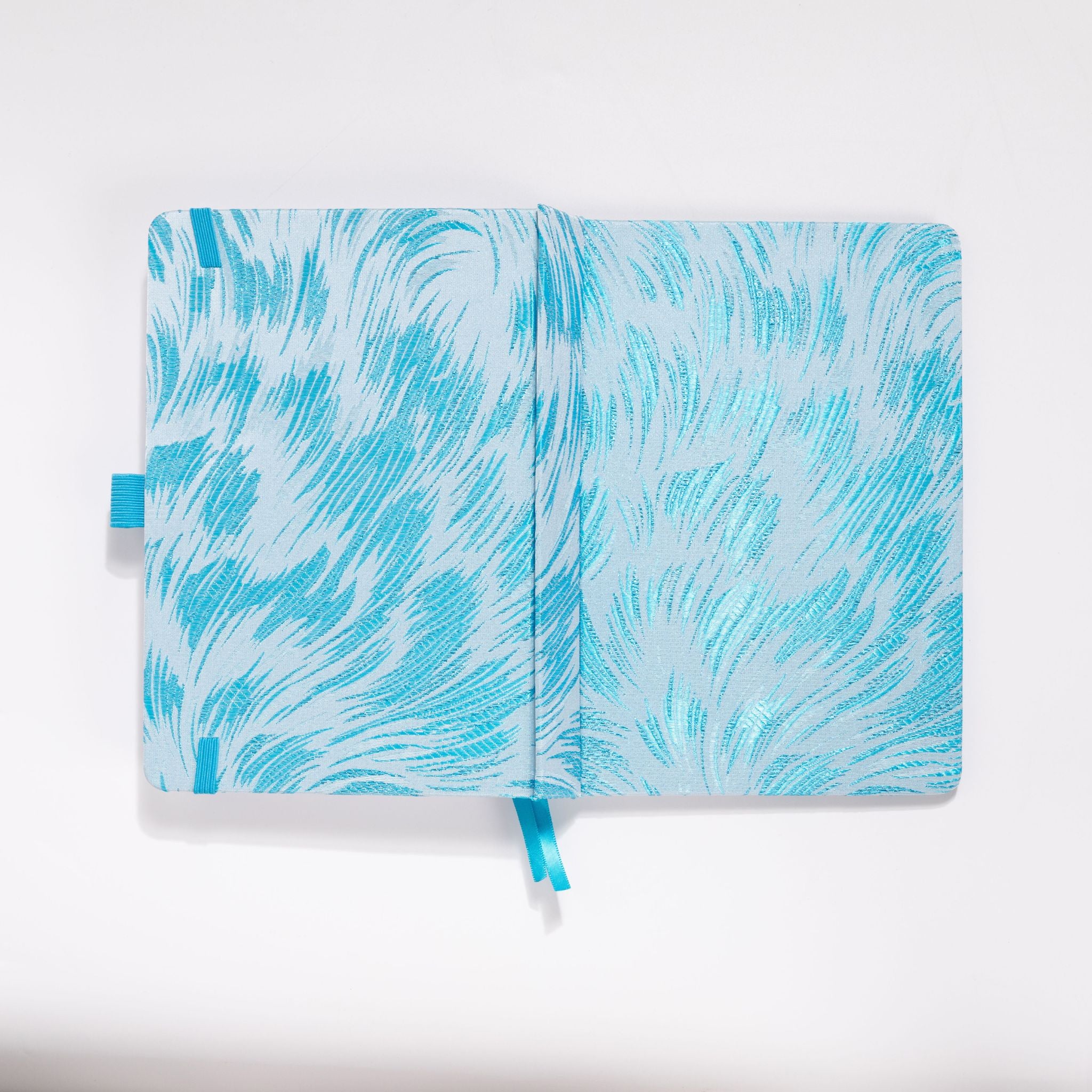 Flat lay of the white and light blue embroidered fabric cover opened completely