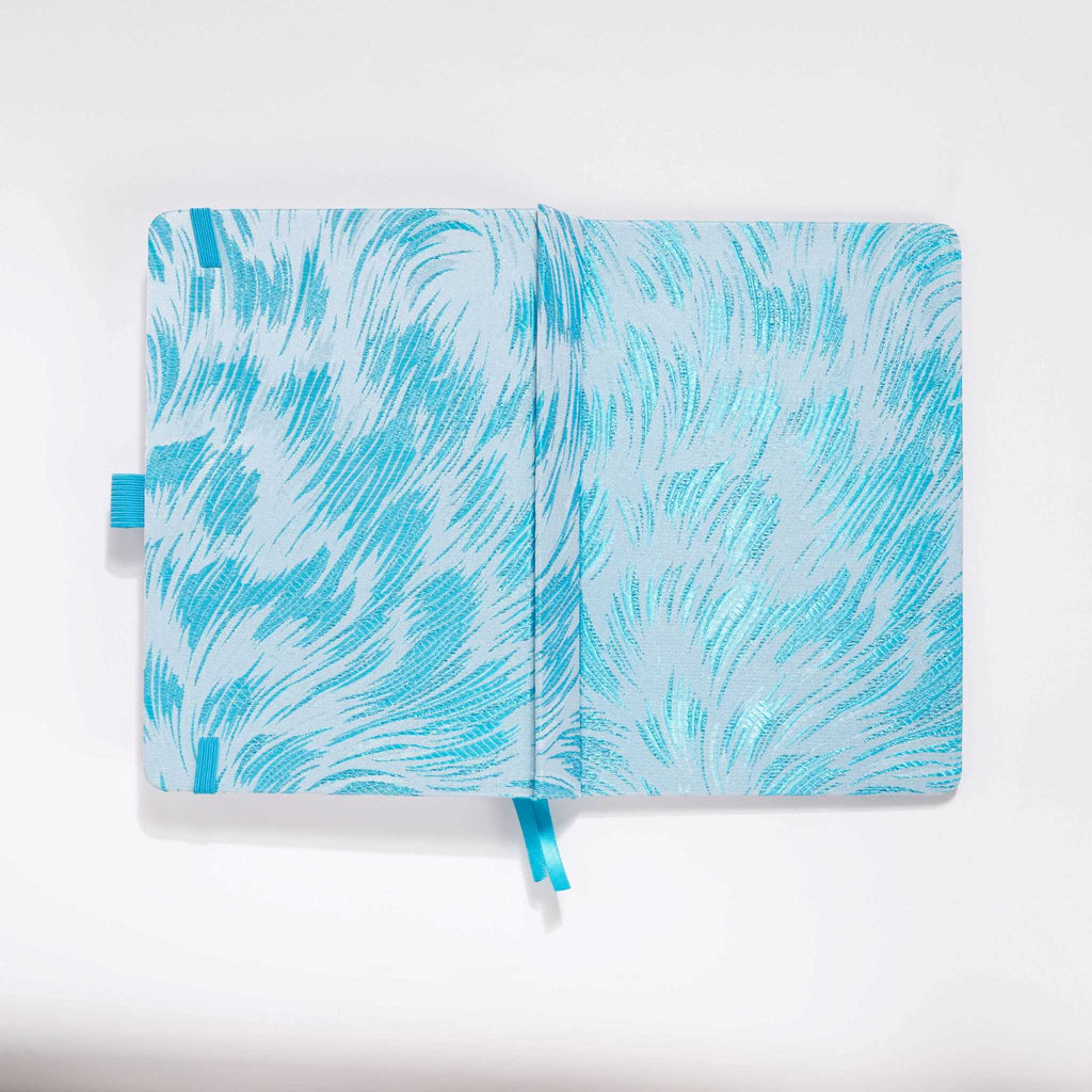 Flat lay of the white and light blue embroidered fabric cover opened completely