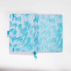 Flat lay of the white and light blue embroidered fabric cover opened completely