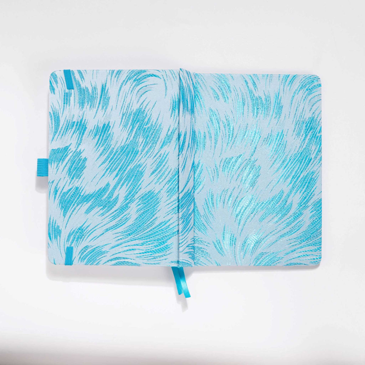 Flat lay of the white and light blue embroidered fabric cover opened completely