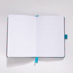 Open A5 notebook showing the 100gsm lined paper interior with teal ribbon bookmark