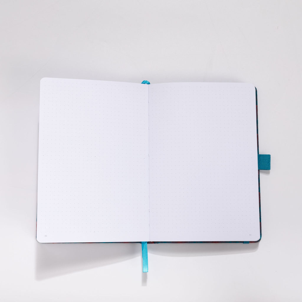 Open A5 journal showing the 160gsm dot grid interior pages