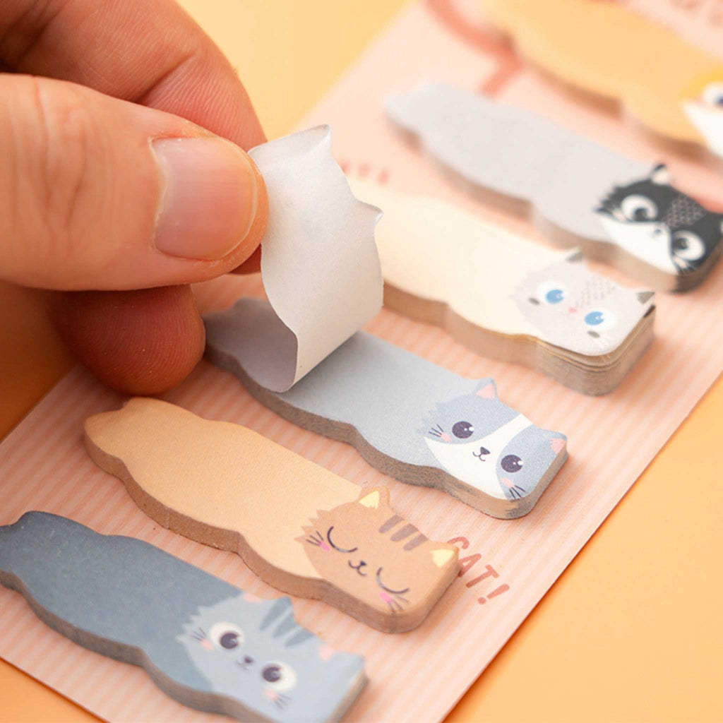 Cat-shaped sticky notes with a hand pulling one out on an orange background