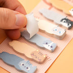 Cat-shaped sticky notes with a hand pulling one out on an orange background