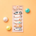 A set of six cat-themed index stickers on a pink card labeled 'The Cat Note Index stickers', arranged on a peach background with decorative paper starburst props.