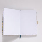 Open A5 journal showing the 160gsm dot grid interior pages with dark blue ribbon bookmark