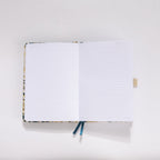 Open A5 notebook showing the 100gsm lined paper interior with date headers