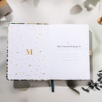 Inside title page featuring a gold foil 'M' logo and 'This Journal Belongs To' section on a green journal