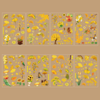 Eight sheets of Ginkgo Song gold foil PET stickers displayed on a warm brown background, featuring golden ginkgo leaves, sunflowers, birds, persimmons, butterflies, and tiny sparkling stars scattered across the designs.