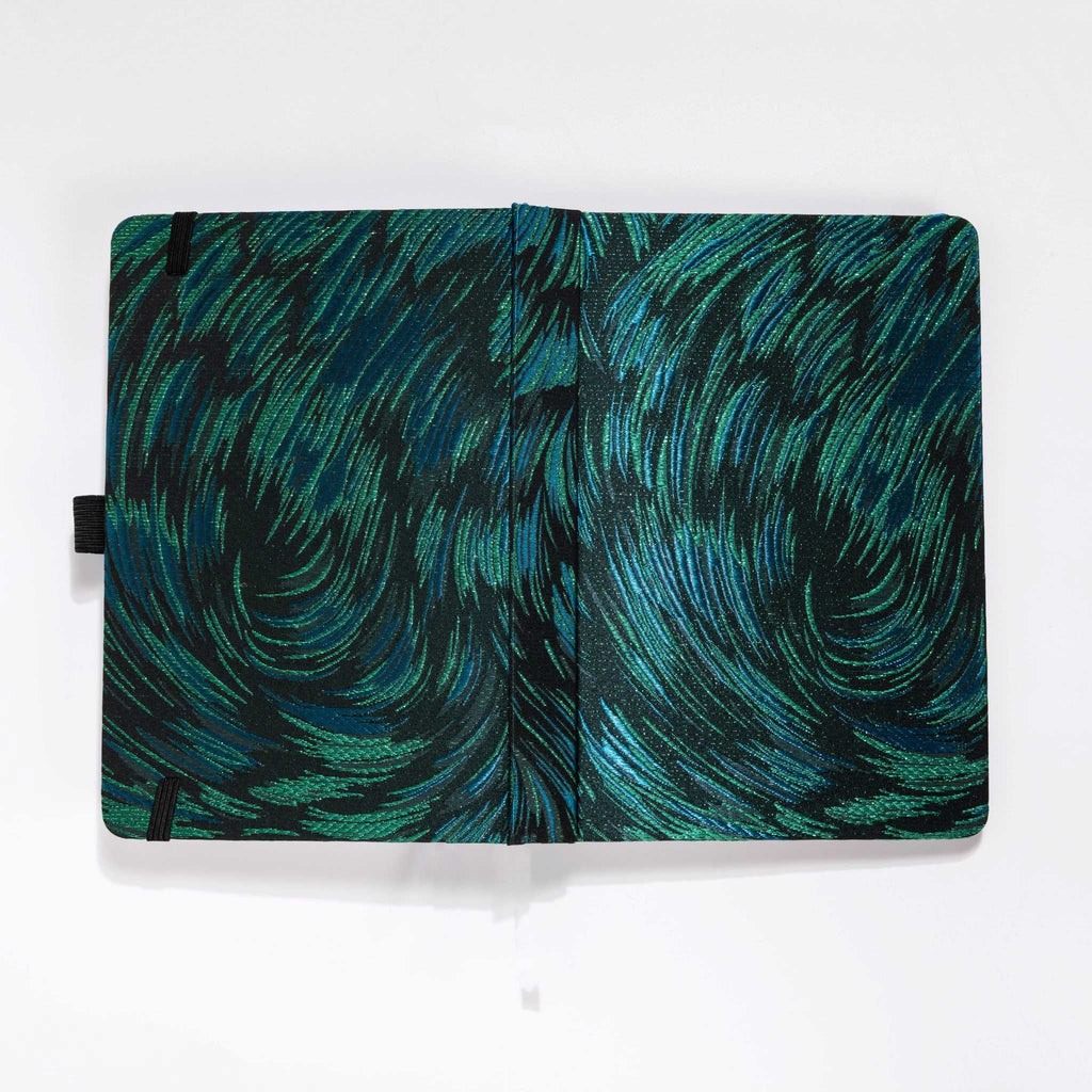 Flat lay of the black and green embroidered fabric cover opened completely