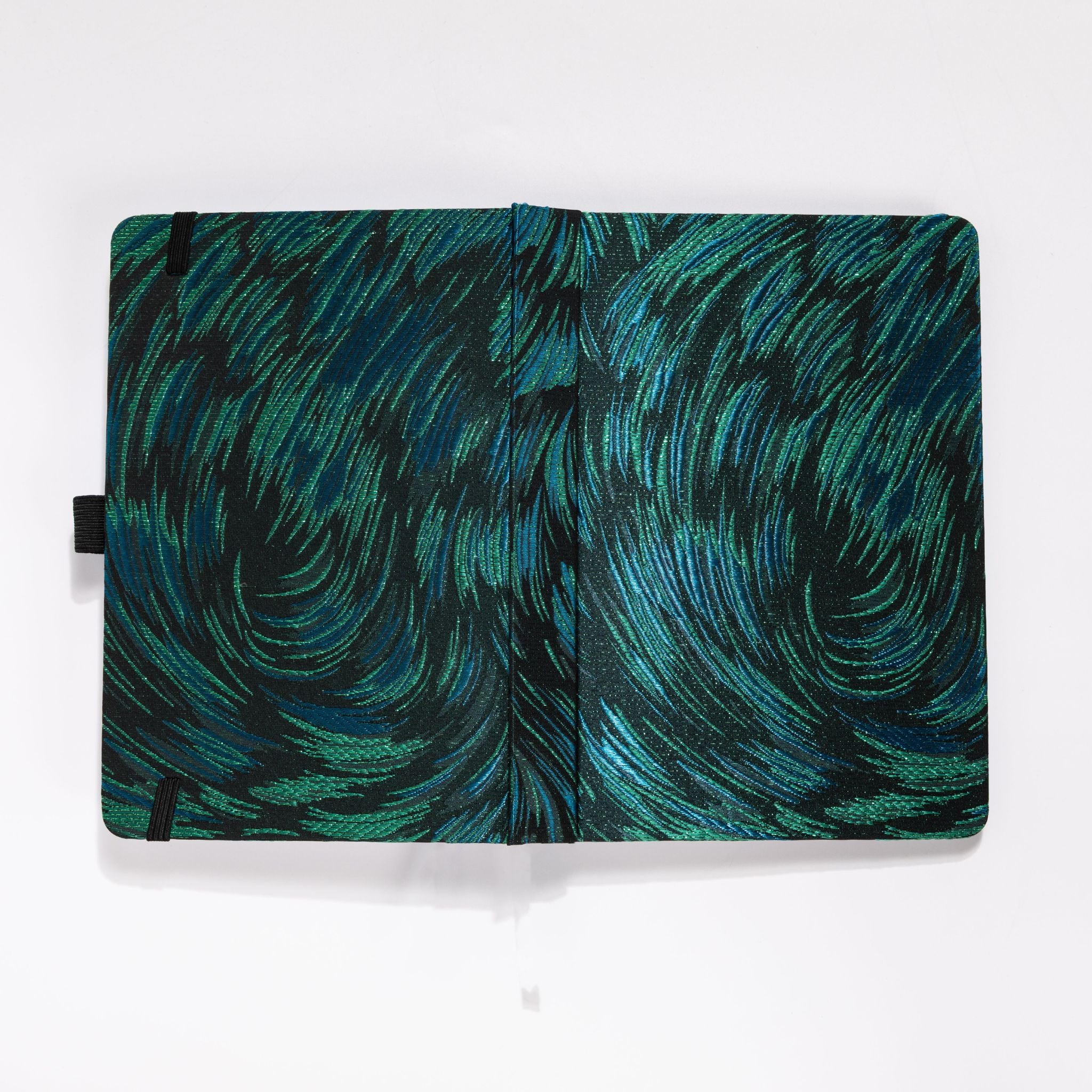 Flat lay of the black and green embroidered fabric cover opened completely