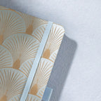 Close-up of the woven green fabric cover with radiating gold scalloped lines and elastic strap