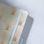 Close-up of the woven green fabric cover with radiating gold scalloped lines and elastic strap