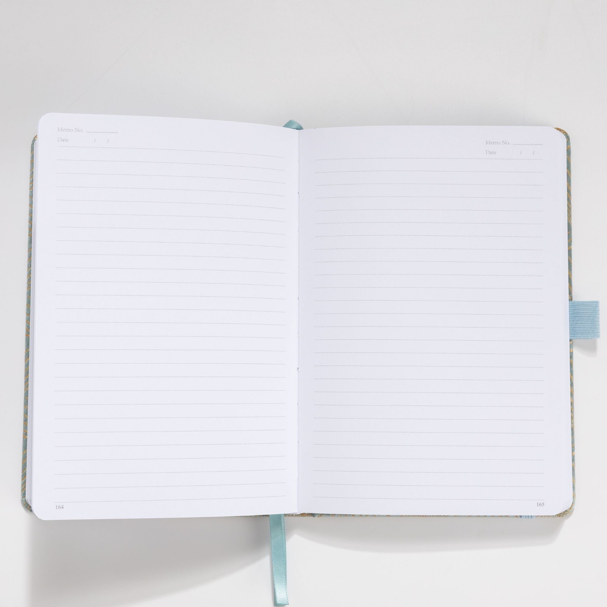 Open A5 notebook showing the 100gsm lined paper interior with date headers and ribbon bookmark
