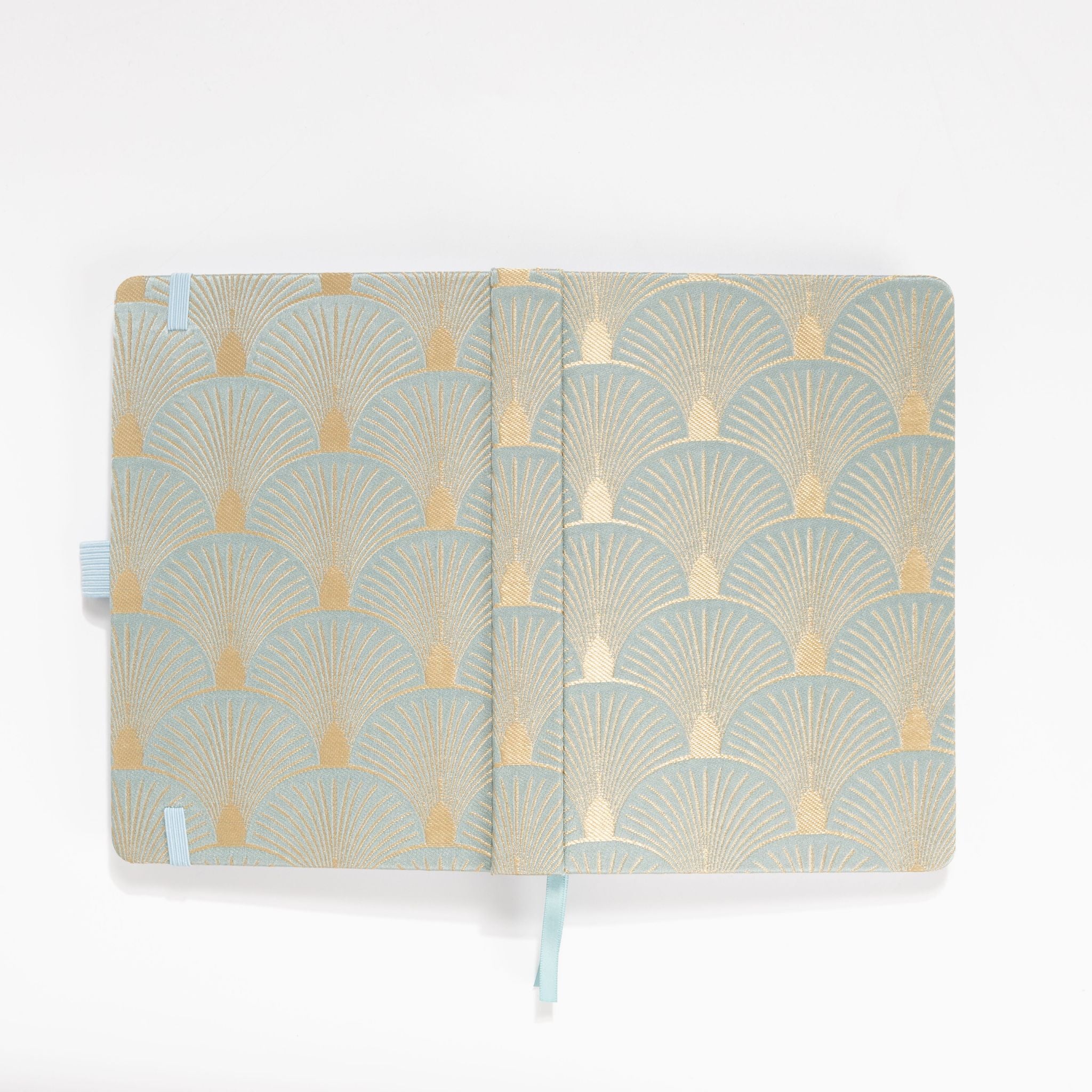 Flat lay of the green and gold scalloped woven fabric cover opened completely.