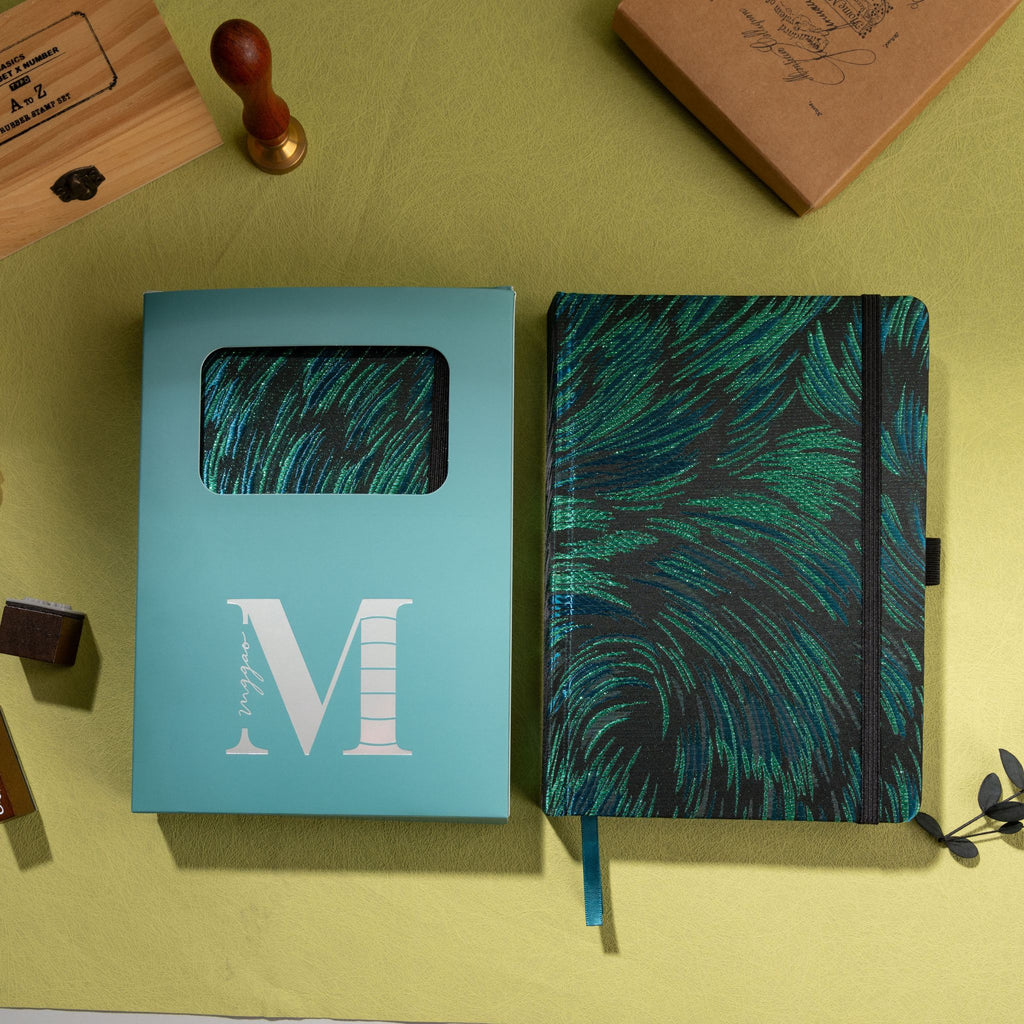 Black and green embroidered fabric notebook displayed next to its signature light blue window-cut gift box