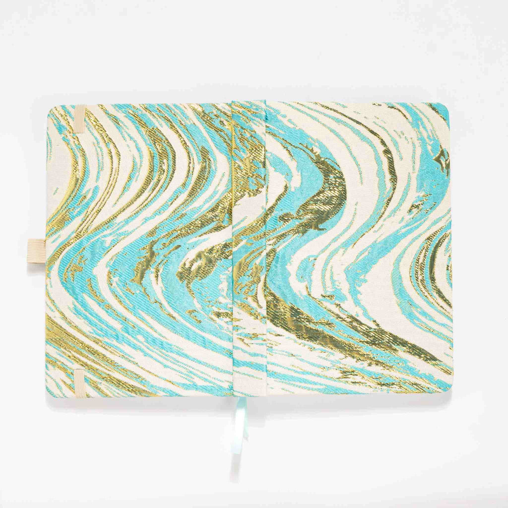 Flat lay of the light blue and gold marble fabric cover opened completely, showing the inner lining and ribbon bookmark